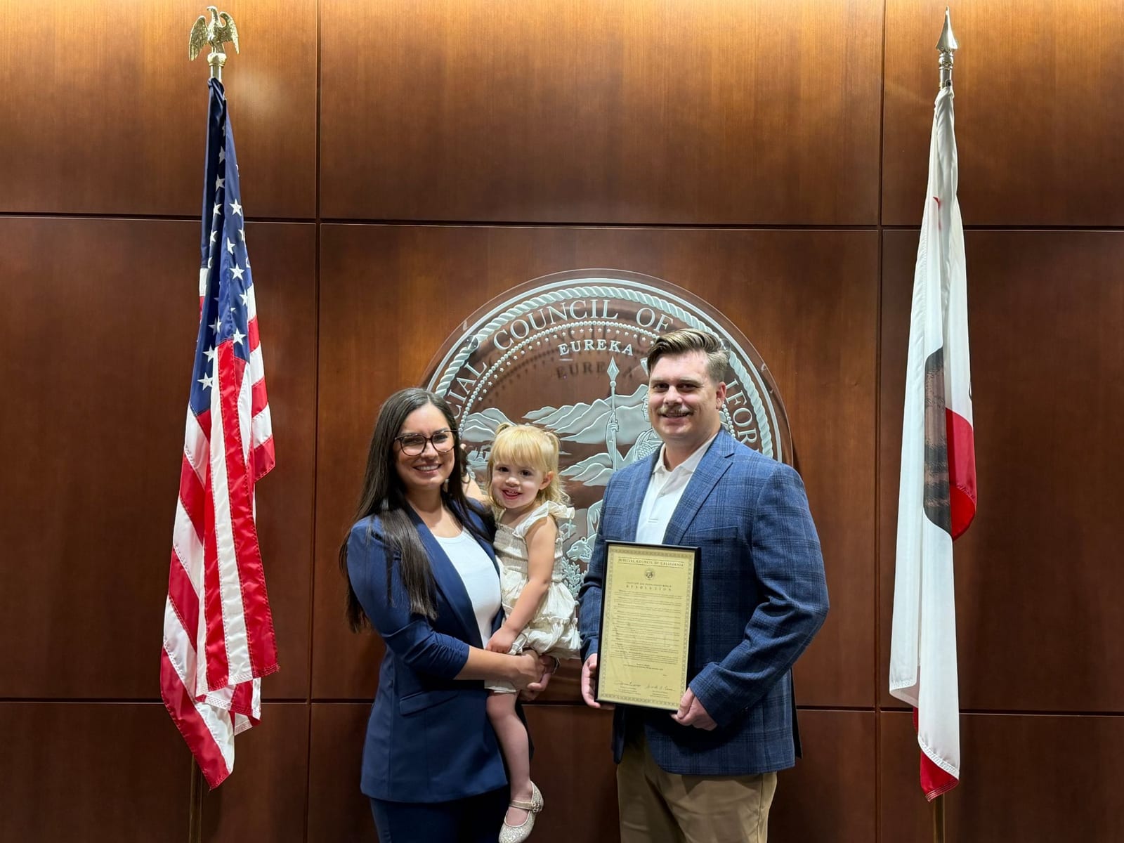 Mike Little with his family at the Judicial Council of California, holding a framed resolution